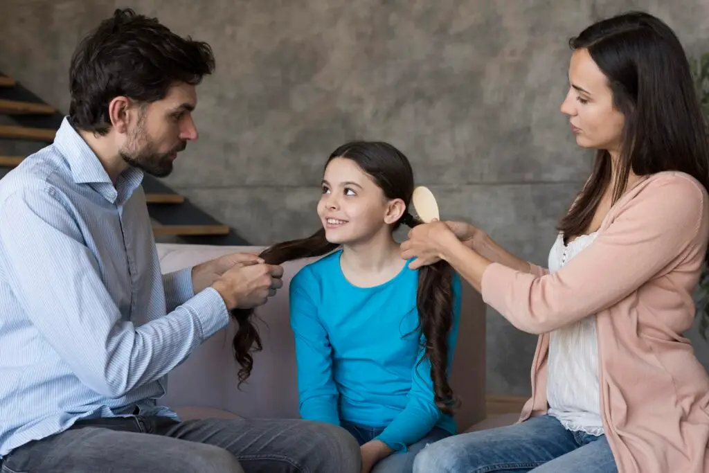 parents-brushing-daughter-hair