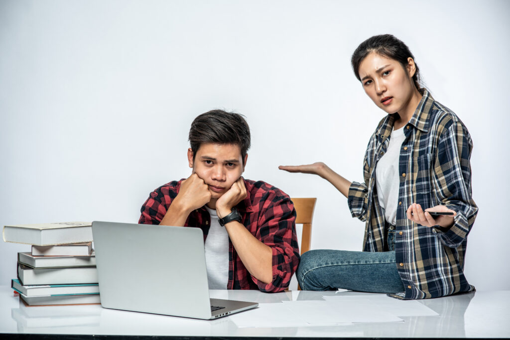 Teacher talking to her student, how to work on Laptop in the Office