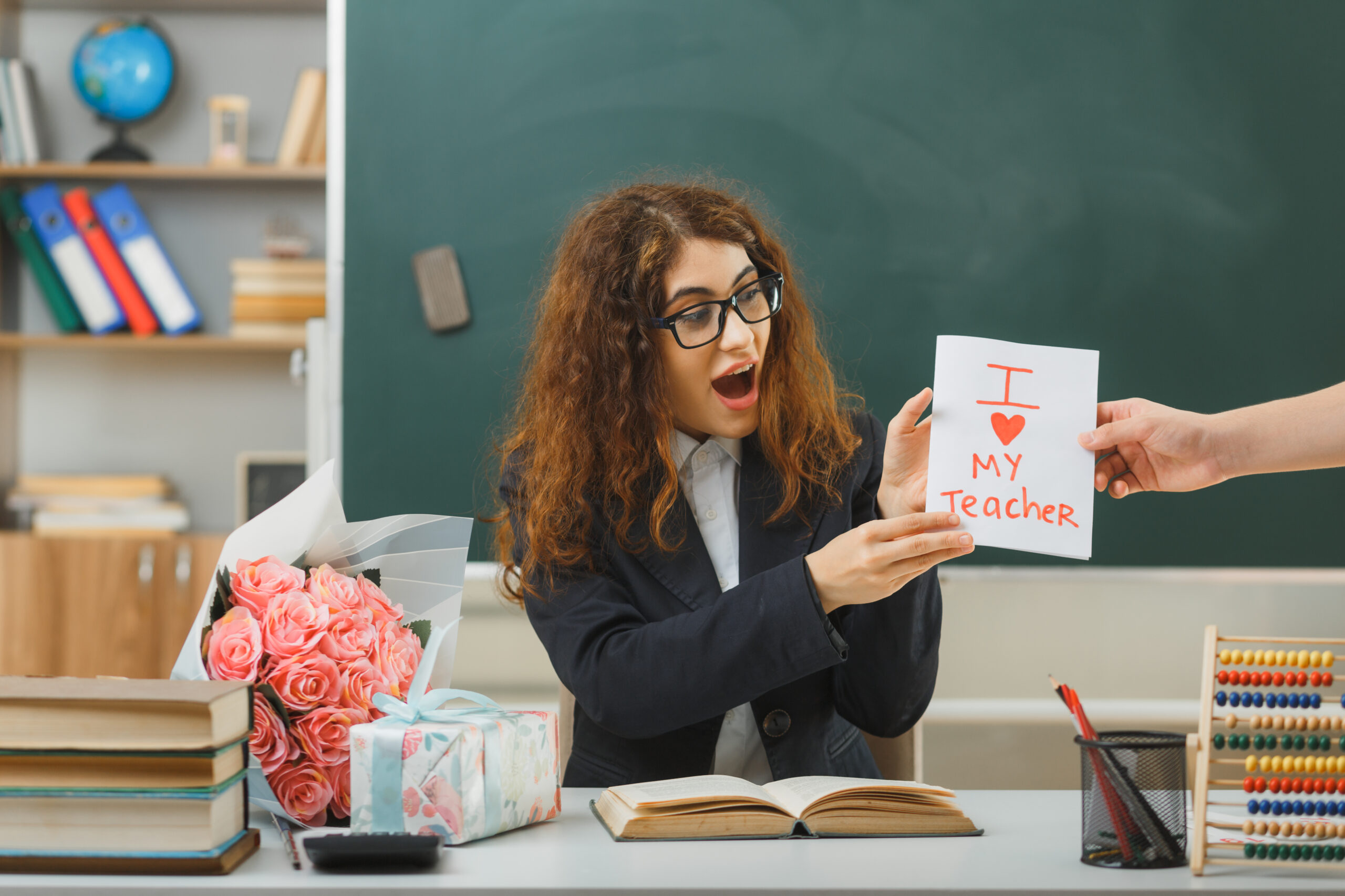 Excited Teacher receives Postcard of Thanks from her Student in Classroom